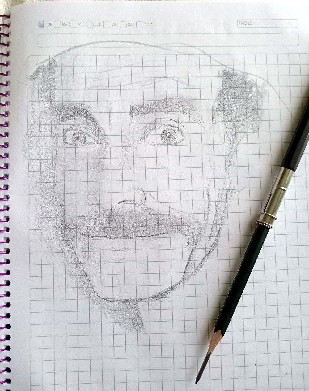 Dibujo a grafito sobre papel de cuader escolar cuadriculado del rostro de Don Ramón sonriendo